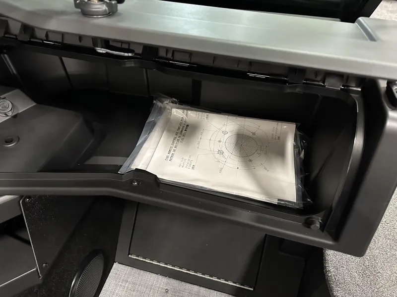 Slide: The Image of Open glove compartment in 2025 Alumacraft Competitor 175X Sport boat with documents inside. - 15