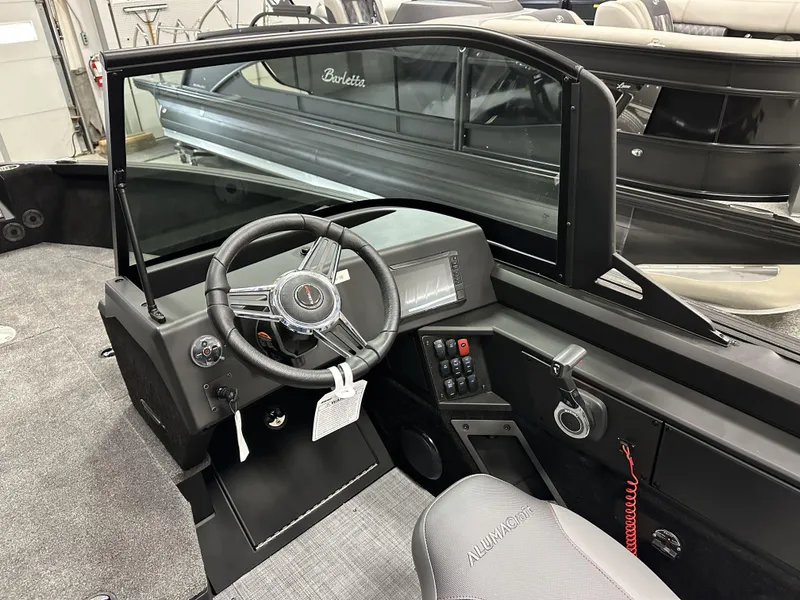 Slide: The Image of 2025 Alumacraft Competitor 175X Sport boat interior with steering wheel and control panel. - 16