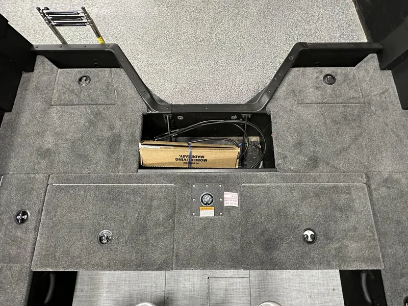 Slide: The Image of 2025 Alumacraft Competitor 175X Sport boat interior with storage compartments and carpeted flooring. - 23