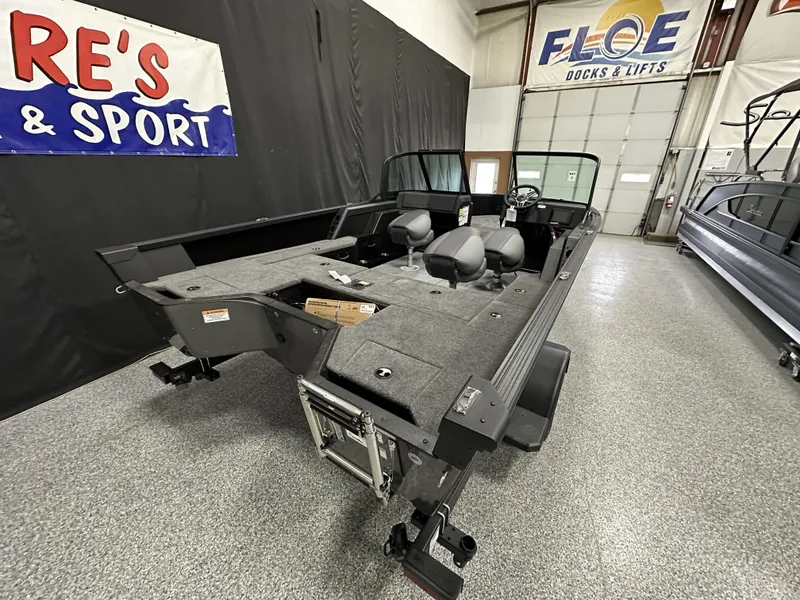 Slide: The Image of 2025 Alumacraft Competitor 175X Sport boat in showroom, featuring spacious interior and modern design. - 26