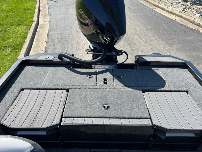 Slide: The Image of 2025 Vexus AVX1985S boat deck with motor, parked on a paved road. - 23