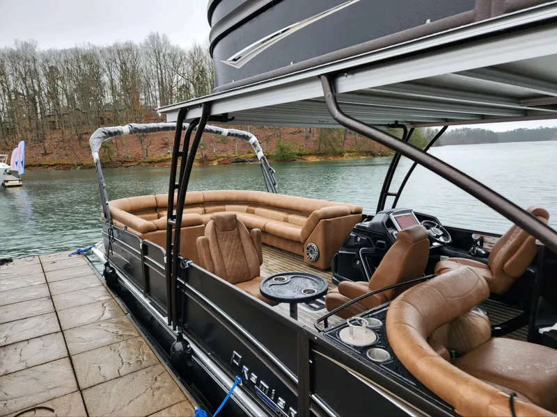 Slide: The Image of 2023 Premier Escalante pontoon boat with luxurious seating, docked by a serene lake. - 4