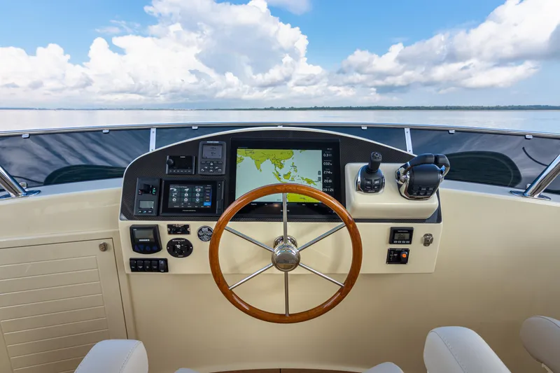 Slide: The Image of Helm of 2021 Palm Beach Motor Yachts PB65 with navigation equipment and wooden steering wheel. - 14