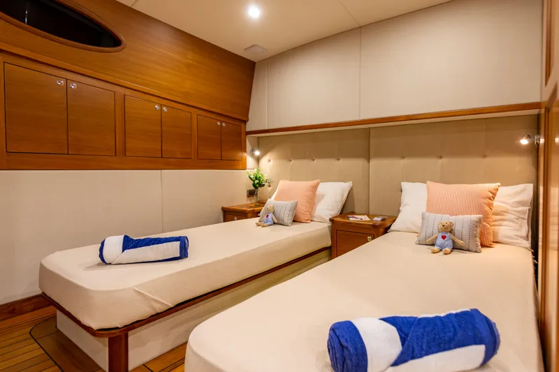 Slide: The Image of Luxurious twin cabin in 2021 Palm Beach Motor Yachts PB65, featuring elegant wood finishes. - 24