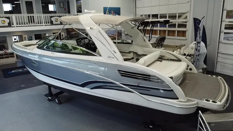 Slide: The Image of 2018 Formula 290 Bowrider boat in showroom, sleek design, gray and white exterior. - 8
