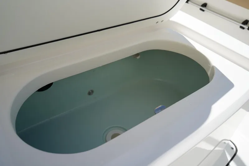 Slide: The Image of Livewell compartment in 2021 Edgewater 188CC boat, open lid, white and blue interior. - 17