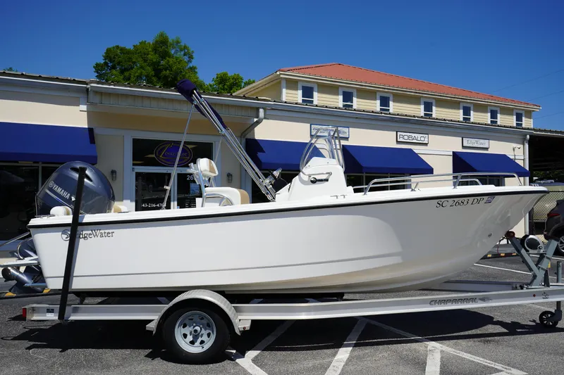 Slide: The Image of 2021 Edgewater 188CC boat on trailer in front of a building with blue awnings. - 2