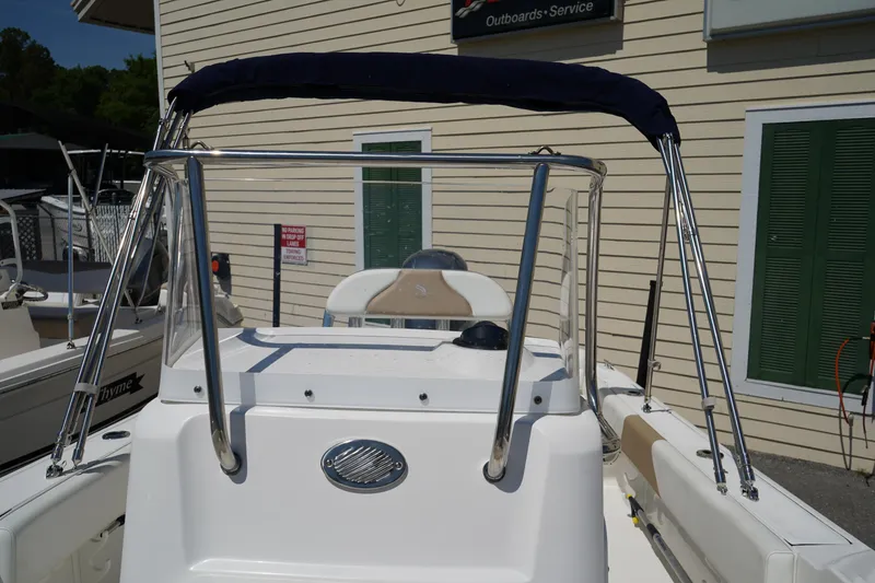 Slide: The Image of 2021 Edgewater 188CC boat with bimini top, docked near service building. - 33