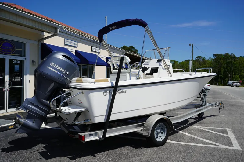 Slide: The Image of 2021 Edgewater 188CC boat on trailer with Yamaha outboard motor, parked outside a building. - 7