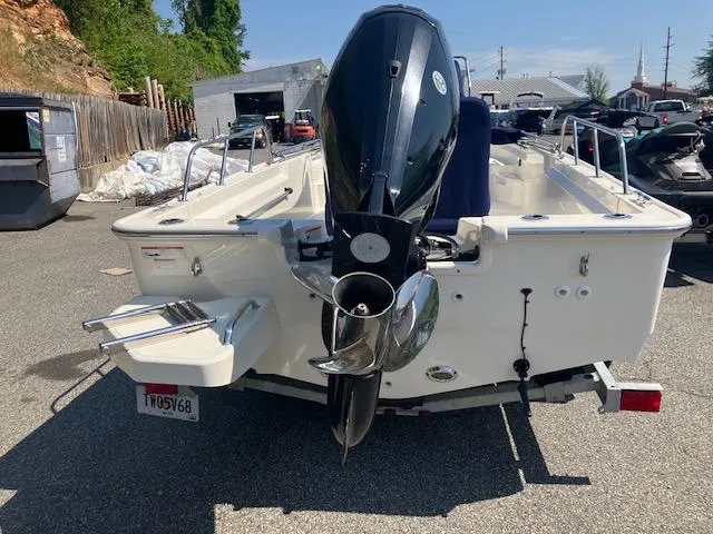 Slide: The Image of 2020 Boston Whaler 170 Montauk boat, rear view with outboard motor, parked outdoors. - 3
