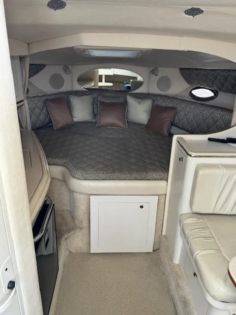 Slide: The Image of 2001 Sea Ray Amberjack cabin interior with bed, cushions, and compact kitchenette. - 6