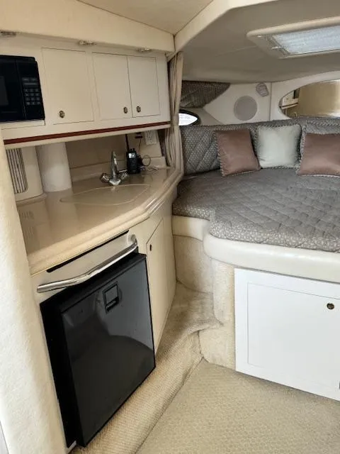 Slide: The Image of 2001 Sea Ray Amberjack cabin interior with kitchenette, bed, and modern amenities. - 7