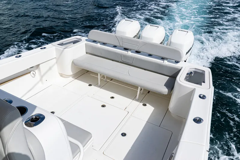 Slide: The Image of 2022 SeaVee 370z boat deck with seating and triple engines on the ocean. - 25