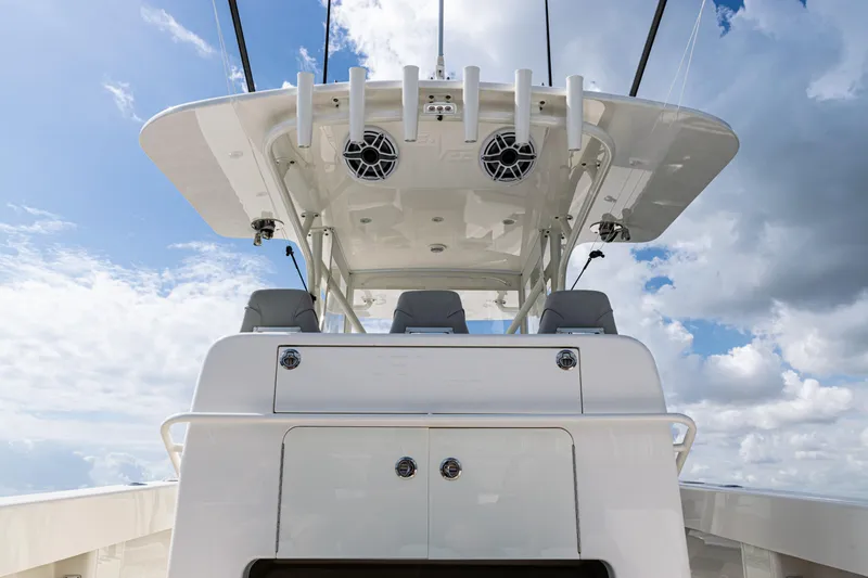 Slide: The Image of 2022 SeaVee 370z boat with sleek design, featuring rod holders and speakers under a cloudy sky. - 43