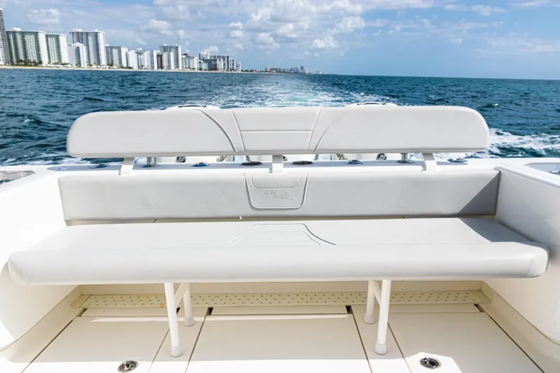 Slide: The Image of 2022 SeaVee 370z boat with rear seating, ocean view, and city skyline in the background. - 45