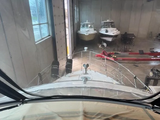Slide: The Image of 2003 Carver 360 Sport Sedan in a boat storage facility with other vessels. - 18