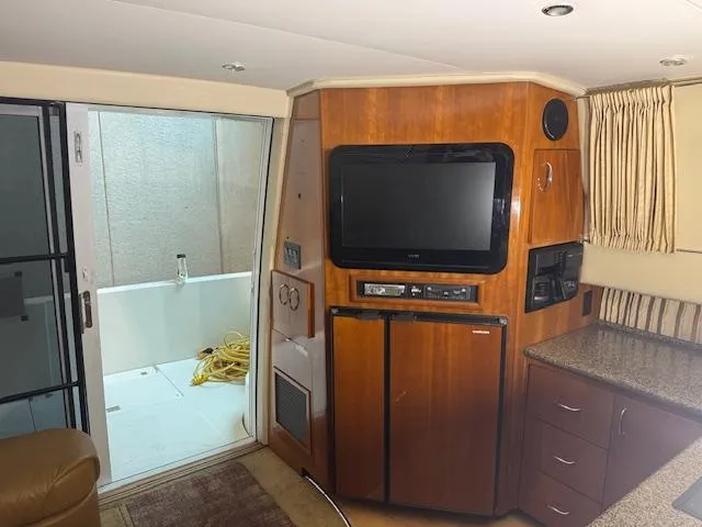 Slide: The Image of Interior of 2003 Carver 360 Sport Sedan with TV, cabinets, and sliding door. - 22