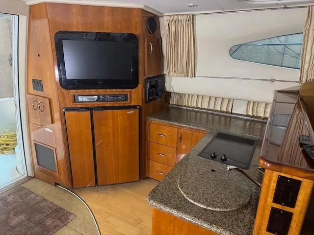 Slide: The Image of Interior of 2003 Carver 360 Sport Sedan with TV, kitchenette, and wood cabinetry. - 27