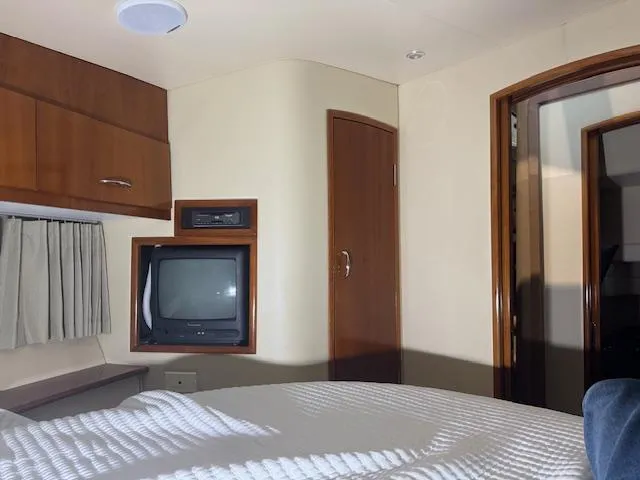 Slide: The Image of Interior of 2003 Carver 360 Sport Sedan with TV, wood cabinets, and cozy bedding. - 40