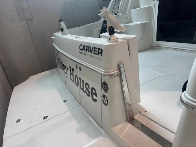 Slide: The Image of 2003 Carver 360 Sport Sedan boat deck with fishing rod holders and branding. - 6