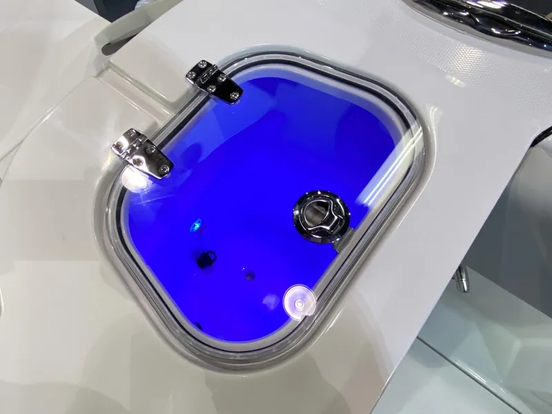 Slide: The Image of 2025 Edgewater 340CC boat livewell with blue interior lighting and secure latch. - 12