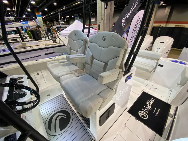 Slide: The Image of 2025 Edgewater 340CC boat interior with plush seating at a boat show. - 2