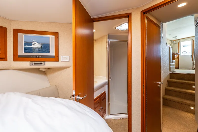 Slide: The Image of Interior of 2004 Cabo 48 Flybridge yacht with bedroom, bathroom, and stairs. - 13