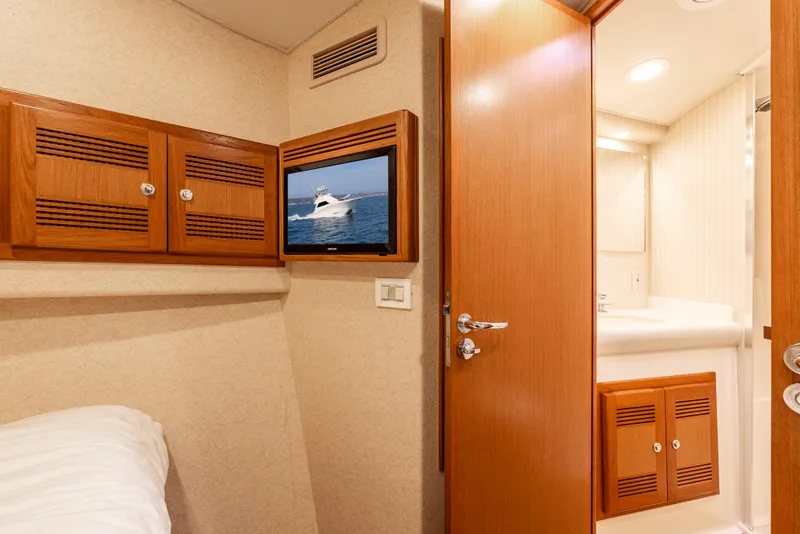Slide: The Image of Interior of 2004 Cabo 48 Flybridge yacht cabin with TV and bathroom. - 19