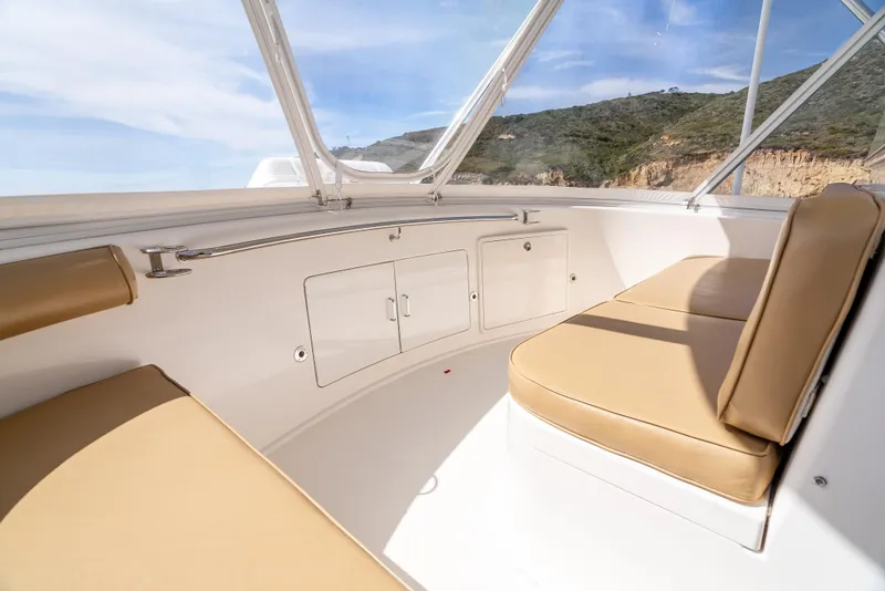 Slide: The Image of 2004 Cabo 48 Flybridge interior with beige seating and storage cabinets. - 26