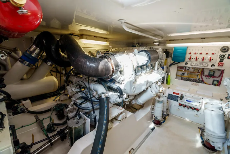 Slide: The Image of Engine room of a 2004 Cabo 48 Flybridge yacht, showcasing machinery and control panels. - 29