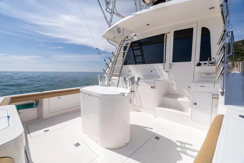 Slide: The Image of 2004 Cabo 48 Flybridge yacht deck with ocean view and fishing equipment. - 36