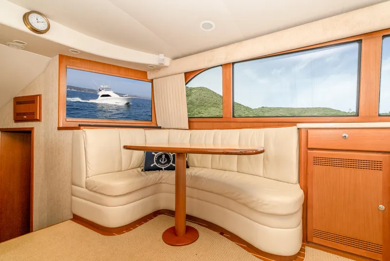 Slide: The Image of Interior of 2004 Cabo 48 Flybridge yacht with plush seating and ocean view. - 5