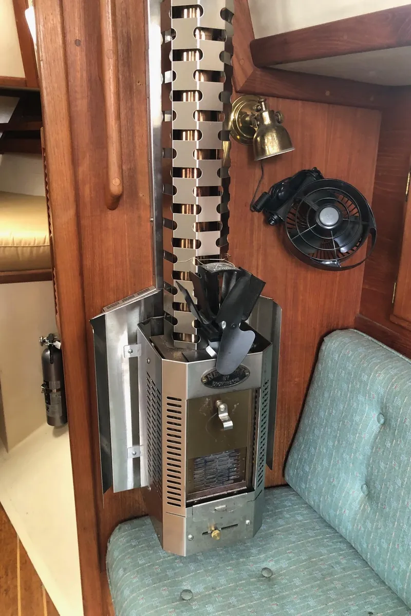 Slide: The Image of 1992 Pacific Seacraft 34 Crealock interior with heater, fan, and wooden paneling. - 10