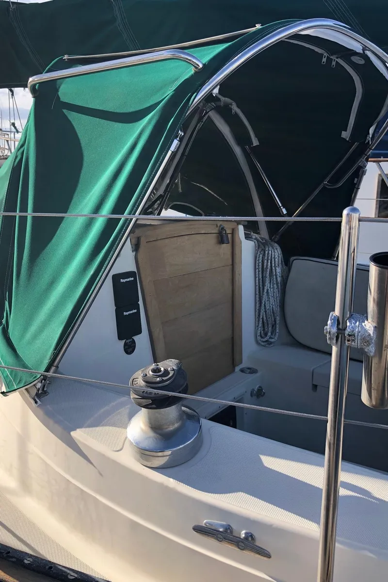 Slide: The Image of 1992 Pacific Seacraft 34 Crealock sailboat with green canopy and winch. - 19