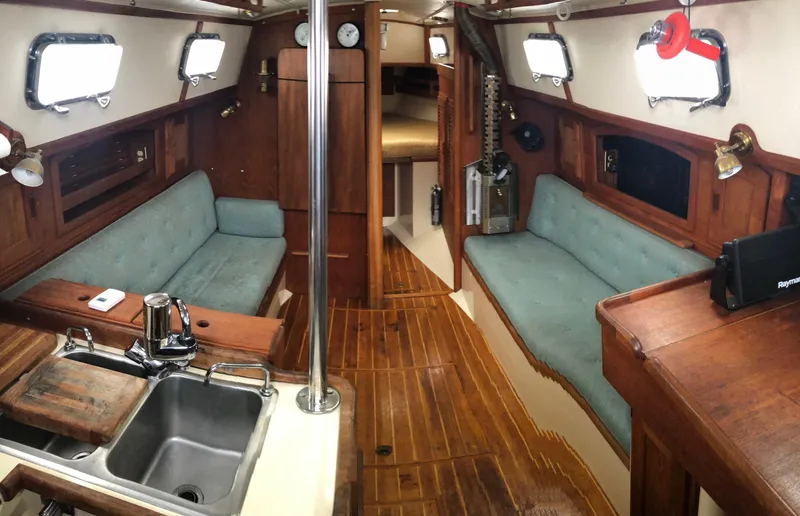 Slide: The Image of Interior of 1992 Pacific Seacraft 34 Crealock sailboat with wood finish and teal seating. - 2