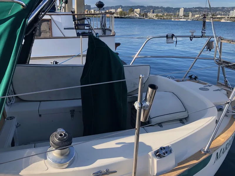 Slide: The Image of 1992 Pacific Seacraft 34 Crealock sailboat docked, featuring a spacious cockpit and green canopy. - 20