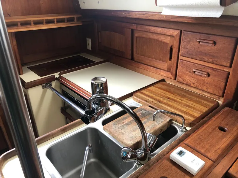 Slide: The Image of 1992 Pacific Seacraft 34 Crealock galley with wooden cabinetry and stainless steel sink. - 3