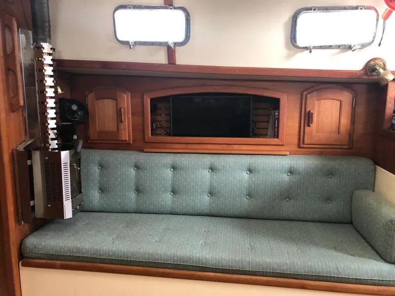 Slide: The Image of Interior of 1992 Pacific Seacraft 34 Crealock with teal cushioned seating and wooden cabinetry. - 9