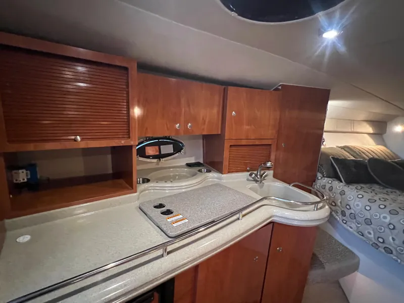 Slide: The Image of 2007 Larson Cabrio 330 interior with wooden cabinets and cozy sleeping area. - 12
