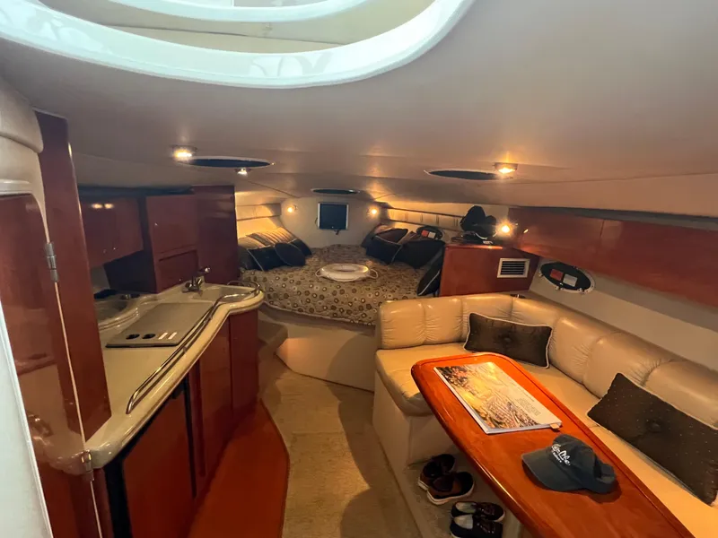 Slide: The Image of 2007 Larson Cabrio 330 cabin interior with kitchen, seating, and bed. - 17