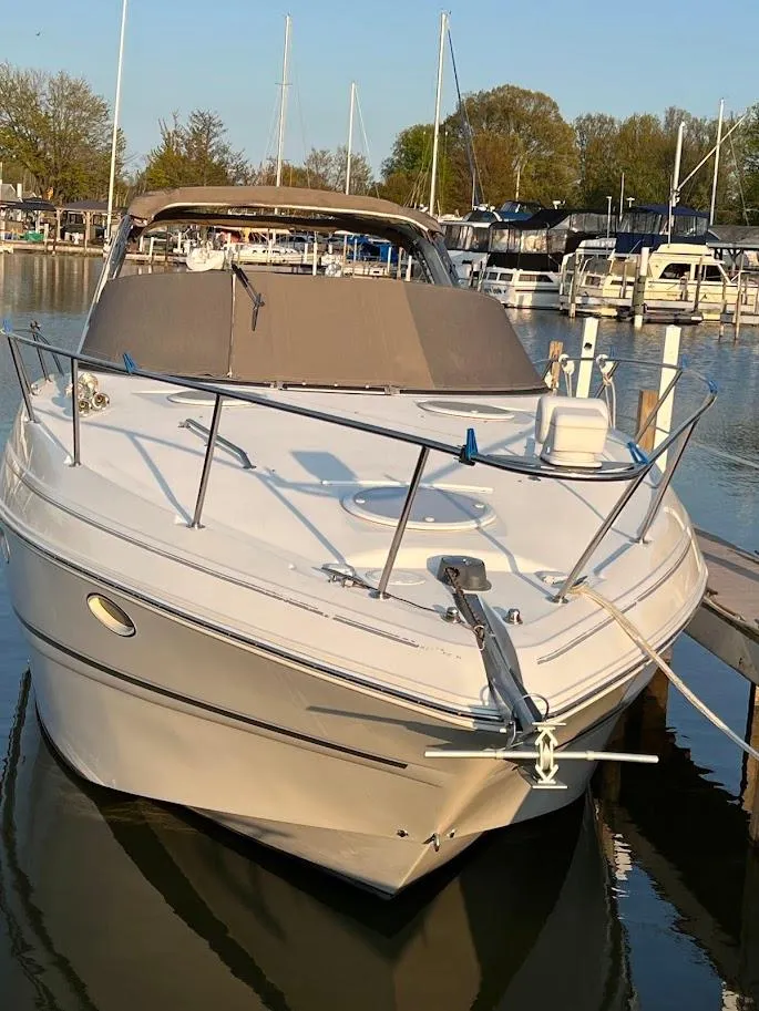 Slide: The Image of 2007 Larson Cabrio 330 boat docked in a marina, surrounded by other vessels. - 2