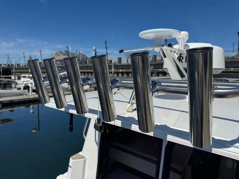 Slide: The Image of 2025 Cutwater C-288 Coupe boat with stainless steel rod holders, docked at a marina. - 13