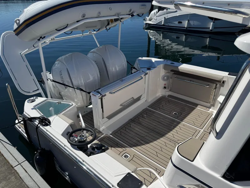 Slide: The Image of 2025 Cutwater C-288 Coupe boat with dual engines and spacious deck at a marina. - 2