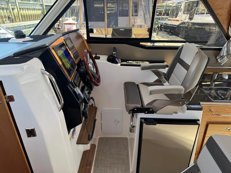 Slide: The Image of 2025 Cutwater C-288 Coupe interior with helm, captain's chair, and navigation equipment. - 20