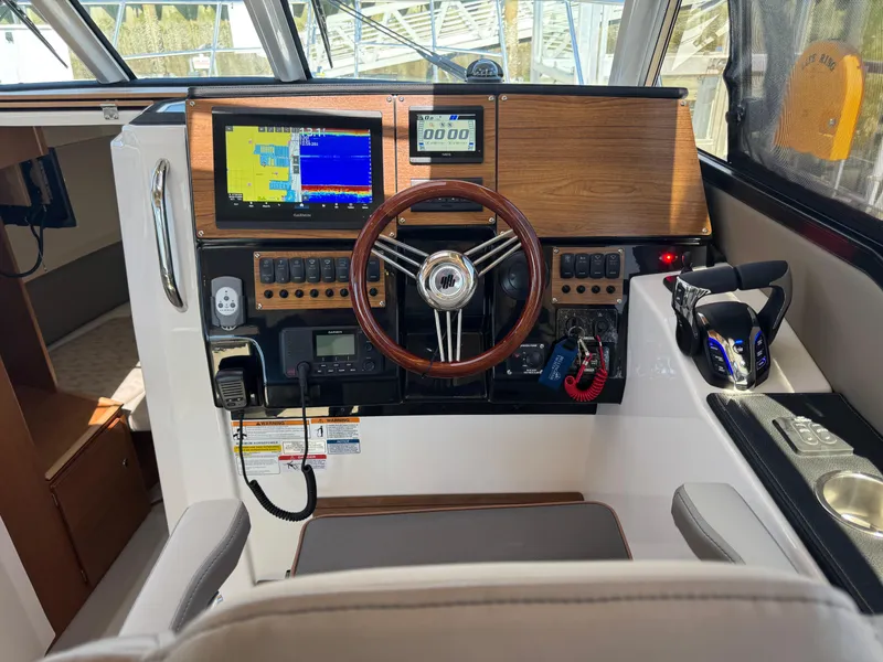 Slide: The Image of 2025 Cutwater C-288 Coupe helm with navigation screens and wooden steering wheel. - 22