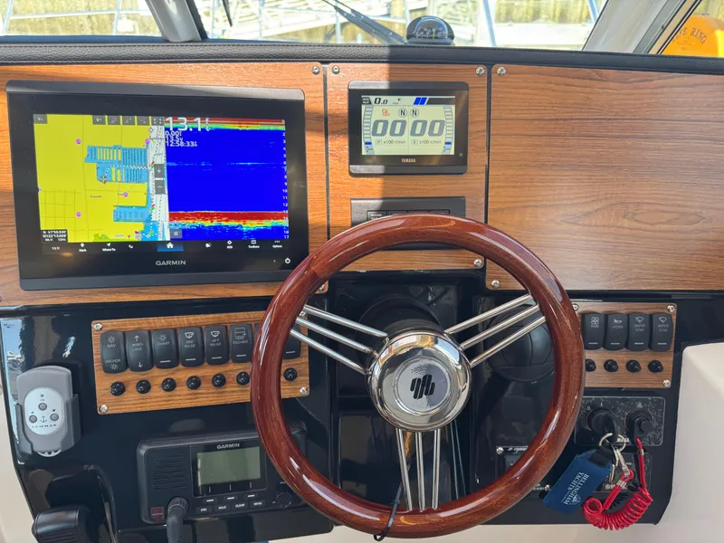 Slide: The Image of Helm of 2025 Cutwater C-288 Coupe with navigation screens and wooden steering wheel. - 23