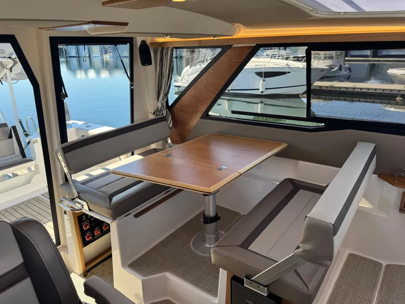 Slide: The Image of Interior of 2025 Cutwater C-288 Coupe, featuring a modern dining area with waterfront view. - 25