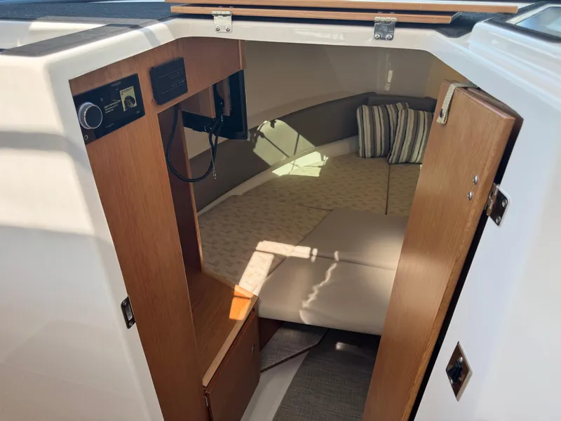Slide: The Image of 2025 Cutwater C-288 Coupe cabin interior with cozy bed and wooden accents. - 26