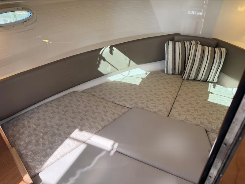Slide: The Image of 2025 Cutwater C-288 Coupe interior cabin with cozy bedding and striped pillows. - 27