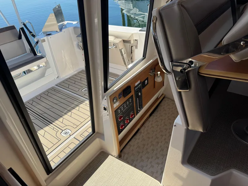 Slide: The Image of 2025 Cutwater C-288 Coupe interior, showcasing cockpit controls and seating with a view of the deck. - 34